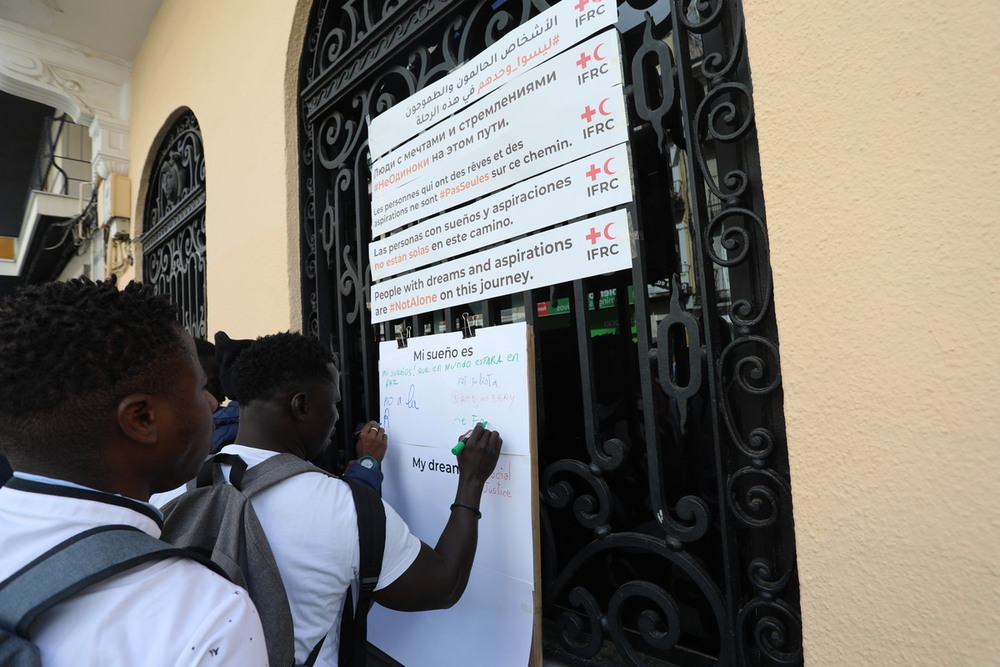 Los participantes de la cadena humana por Carretería portan mensajes de apoyo a las personas refugiadas